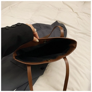 Detailed view of the brown PU leather tote bag showing a large capacity interior and magnetic clasp