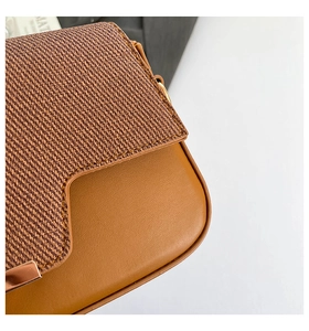 Close-up of stylish crossbody bag showing woven texture and smooth leather stitching