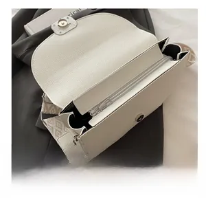 Dettaglio della borsa in pelle bianca con tasca interna a zip e tracolla jacquard