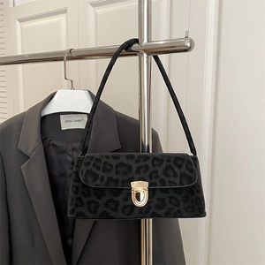 Chic black leopard print underarm bag with gold metal buckle on display rack
