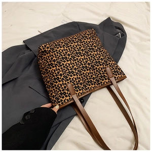 Detail of leopard print tote bag with brown faux leather straps and sturdy stitching