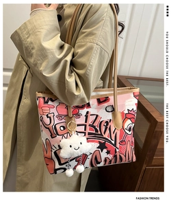 Detail of red and black graffiti tote bag with a white plush cloud pendant
