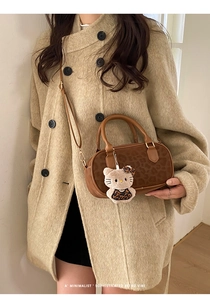 Dettaglio borsa Boston marrone con stampa leopardata, doppi manici e ciondolo di peluche