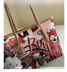 Close-up of graffiti canvas tote bag with faux leather strap and plush cloud charm