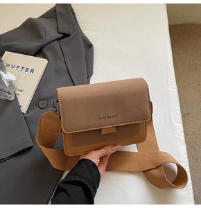 Detail of two-tone caramel PU leather crossbody bag with wide strap and fashion logo