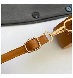 Detail of brown leather strap with golden metal buckle and stitching for saddle bag