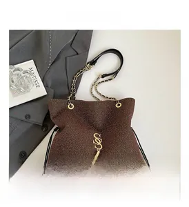 Detail of dark brown sequin drawstring tote with gold S-logo and chain strap