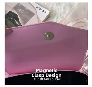 Close-up of pink leather crossbody bag showing functional magnetic closure and ribbon detail