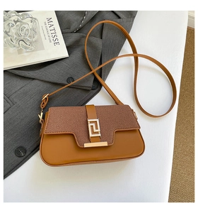 Detailed macro view of the brown saddle bag featuring its fabric texture and golden buckle