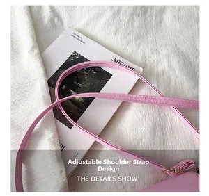 Close-up of pink synthetic leather adjustable shoulder strap with gold metal buckle