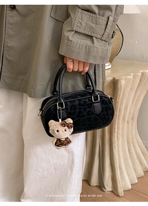Dettaglio borsa retrò leopardata con ciondolo in peluche e chiusura in oro