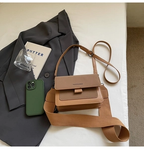 Detail of crossbody bag with wide textile strap and brown faux leather patchwork