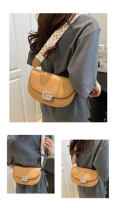Détail du sac à main en cuir caramel avec boucle en strass et bandoulière géométrique