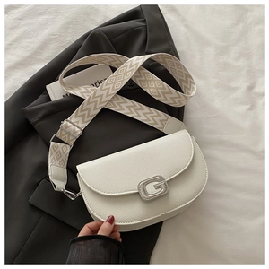 Détail du sac de selle en cuir grainé blanc avec bandoulière jacquard et boucle argentée
