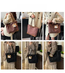 Vue détaillée du grand sac cabas noir et marron avec breloque ours et bandoulière