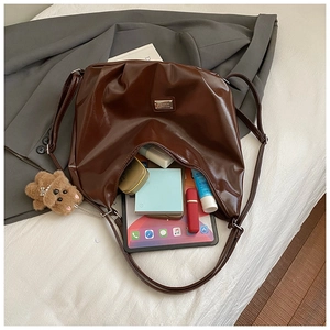 Interior detail of large brown tote bag showing spacious storage for tablet and cosmetics