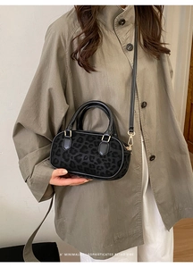 Dettaglio mini borsa leopardata nera con trama in velluto e fibbie dorate