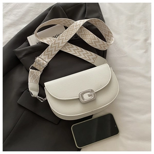 Détail du sac à main en cuir grainé blanc avec boucle G et bandoulière tissée