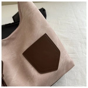 Detail von rosa mattem Stoff und braunem Lederbeutel-Stich auf einer schicken Handtasche