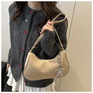 Dettaglio della borsa hobo beige con ciondolo a fiocco di strass argentati lucidi