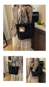 Détail d'un grand sac cabas noir avec tissu texturé et charmant petit ours brun