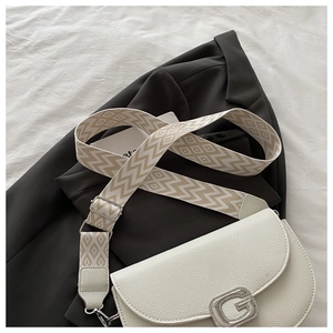 Détail du sac blanc en cuir litchi avec boucle G en cristal et bandoulière à motifs