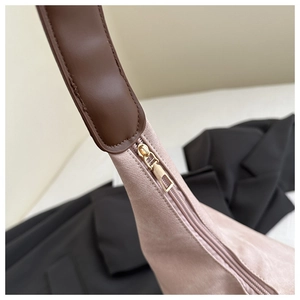 Detail der Canvas-Schultertasche mit präzisen Nähten, Lederriemen und goldenem Reißverschluss
