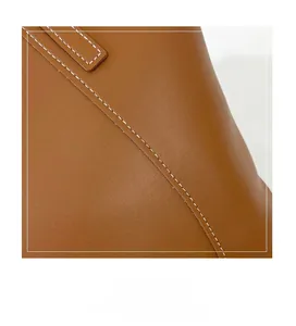 Gros plan du sac cabas en cuir marron montrant les détails des coutures blanches