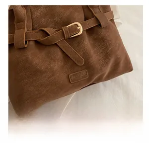 Detail of vintage brown pebble leather handbag with gold buckle and Fashion logo