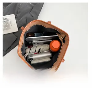 Internal view of brown tote bag showing large capacity for laptop and essentials