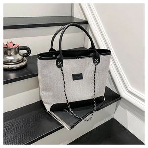 Chic large capacity tote bag with black trim, chain strap and elegant woven texture