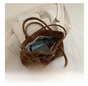 Interior view showing the large capacity of the brown suede tote bag with daily items