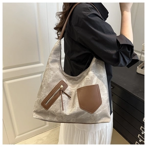 Detailansicht der Canvas-Einkaufstasche mit braunen Ledertaschen und elegantem Metall-Reißverschluss