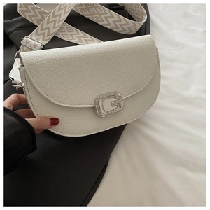 Détail du sac selle en cuir grainé blanc avec fermoir en G en métal et bandoulière large