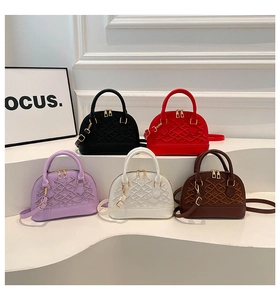 Detail of mini dome bags in five colors with diamond weave texture and gold hardware