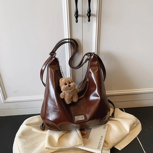 Classic dark brown tote bag in oily leather finish with a cute plush bear pendant