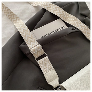 Gros plan du sac à main blanc texturé avec bandoulière large tissée géométrique
