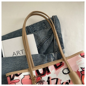 Detail of pink graffiti canvas tote with khaki leather trim and gold metal ring hardware
