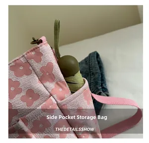 Close-up of functional side pocket on floral tote bag holding a compact green umbrella