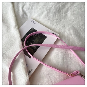 Close-up of pink PU leather shoulder strap with gold metal buckle and stitching details