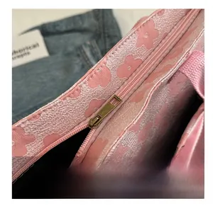 Detailed close-up of smooth gold metal zipper and pink floral canvas tote bag
