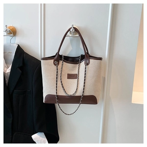 Bolso tote grande de lona beige con ribete de cuero marrón y correa de cadena de metal