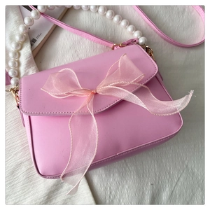Detail of pink crossbody bag with organza bow and pearl bead shoulder strap