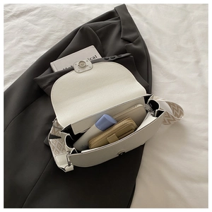 Détail de l'intérieur du sac selle blanc montrant la capacité et le cuir grainé