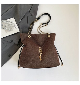 Dettaglio della borsa marrone glitterata con logo SS dorato, nappe e tracolla a catena