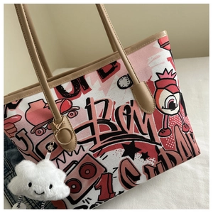 Detail of canvas tote bag with street graffiti print and a white cloud plush charm