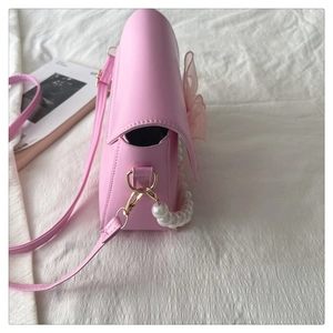 Detail of pink PU leather bag featuring organza bow and elegant pearl handle strap