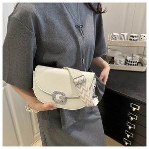 Détail du sac blanc cassé en cuir grainé avec boucle G argentée et bandoulière large