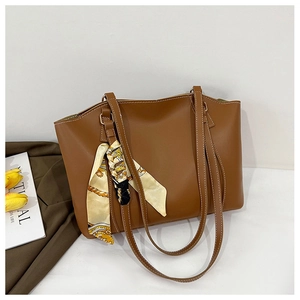 Détail d'un sac cabas marron avec surpiqûres blanches et foulard en soie vintage décoratif