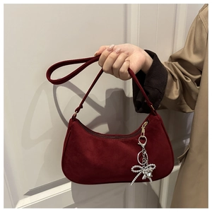 Close-up of deep red frosted suede hobo bag with a silver beaded bow charm detail